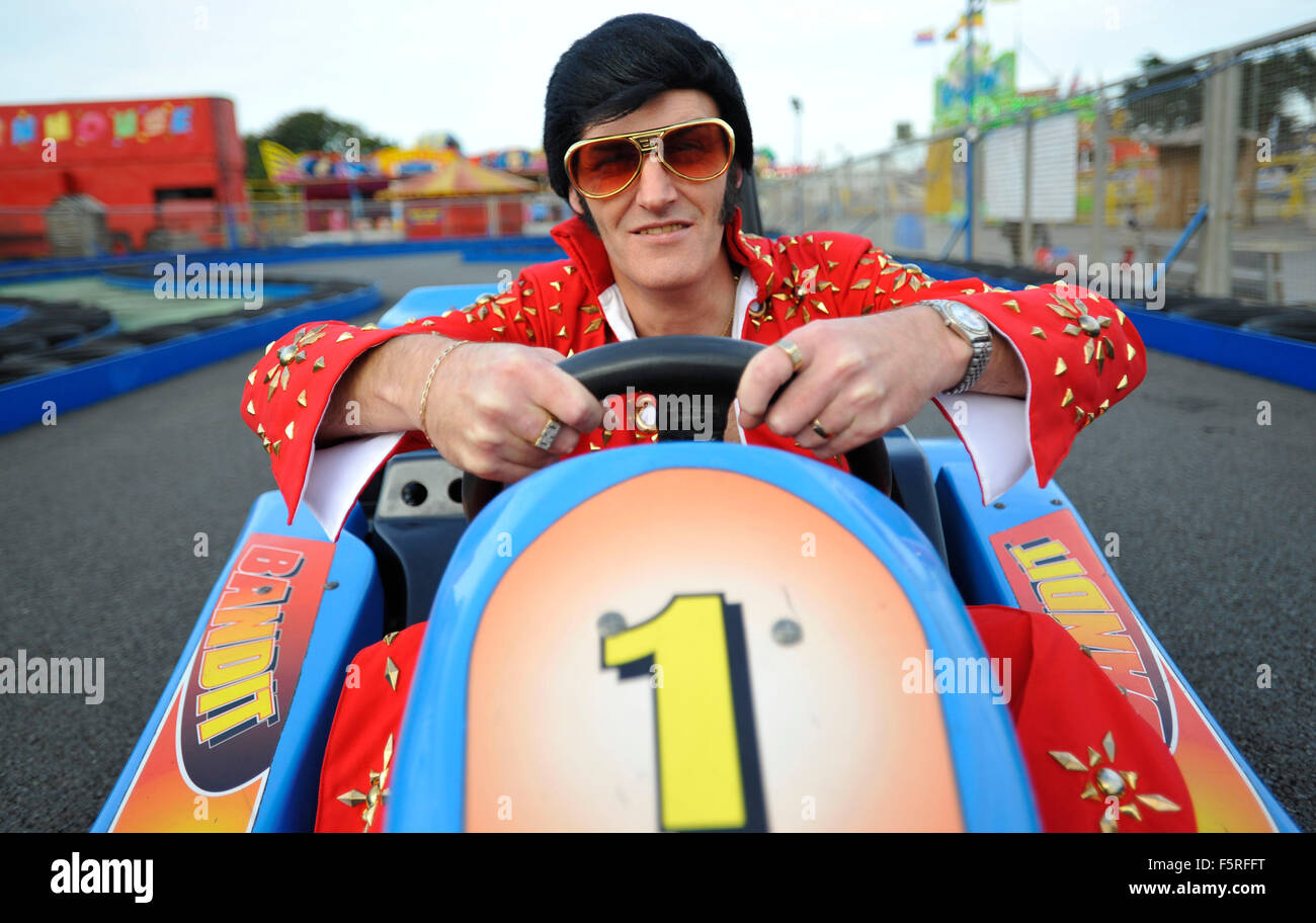 A Elvis impersonator rides a go kart at Coney Beach Amusement Park in Porthcawl, South Wales during the annual Elvis Festival. Stock Photo