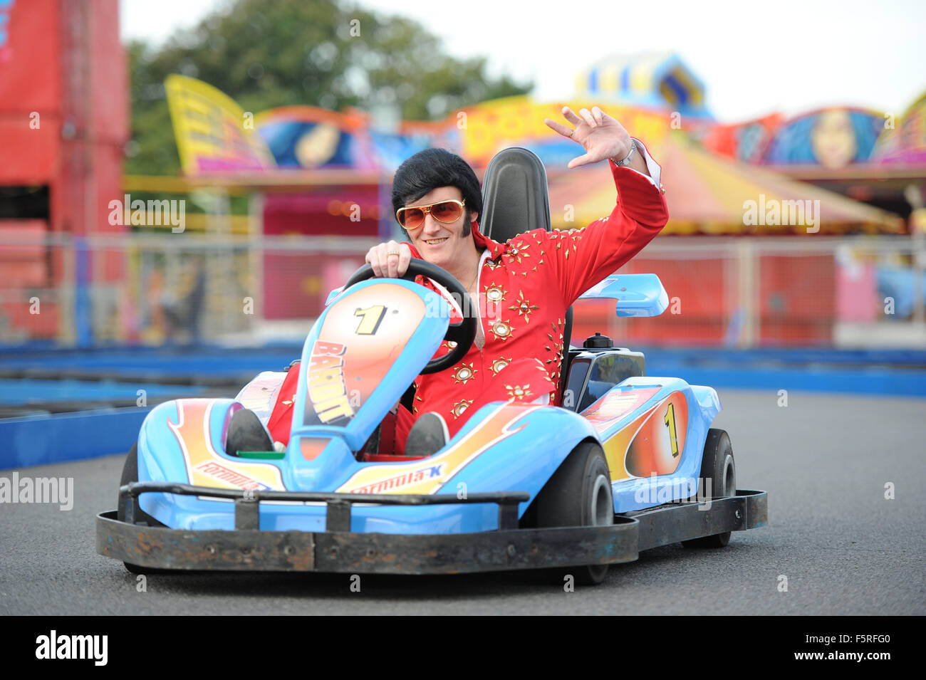 A Elvis impersonator rides a go kart at Coney Beach Amusement Park in Porthcawl, South Wales during the annual Elvis Festival. Stock Photo