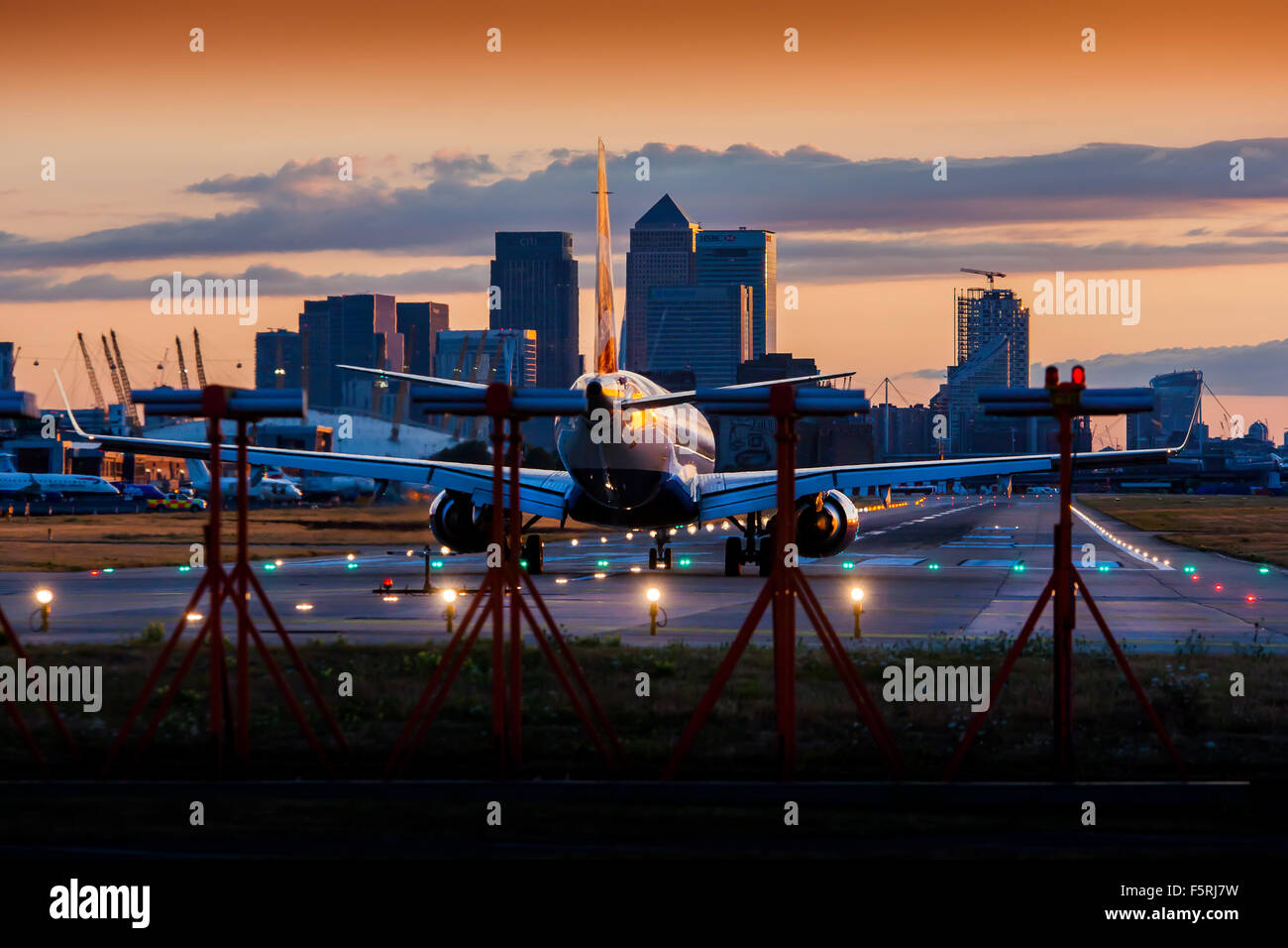 A passenger jet plane waiting to depart on the runway at London City Airport Stock Photo