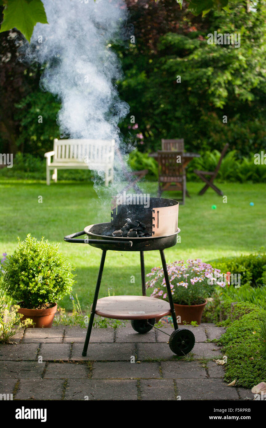 Germany, Gifhorn, Barbecue grill in backyard Stock Photo