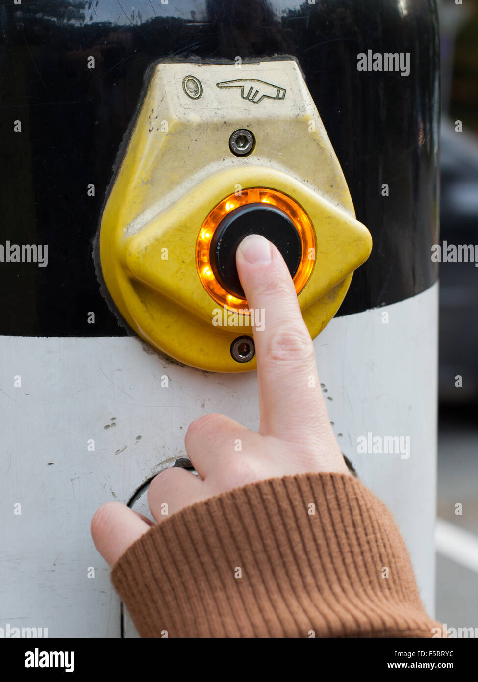 Female hand pushing button for traffic light Stock Photo