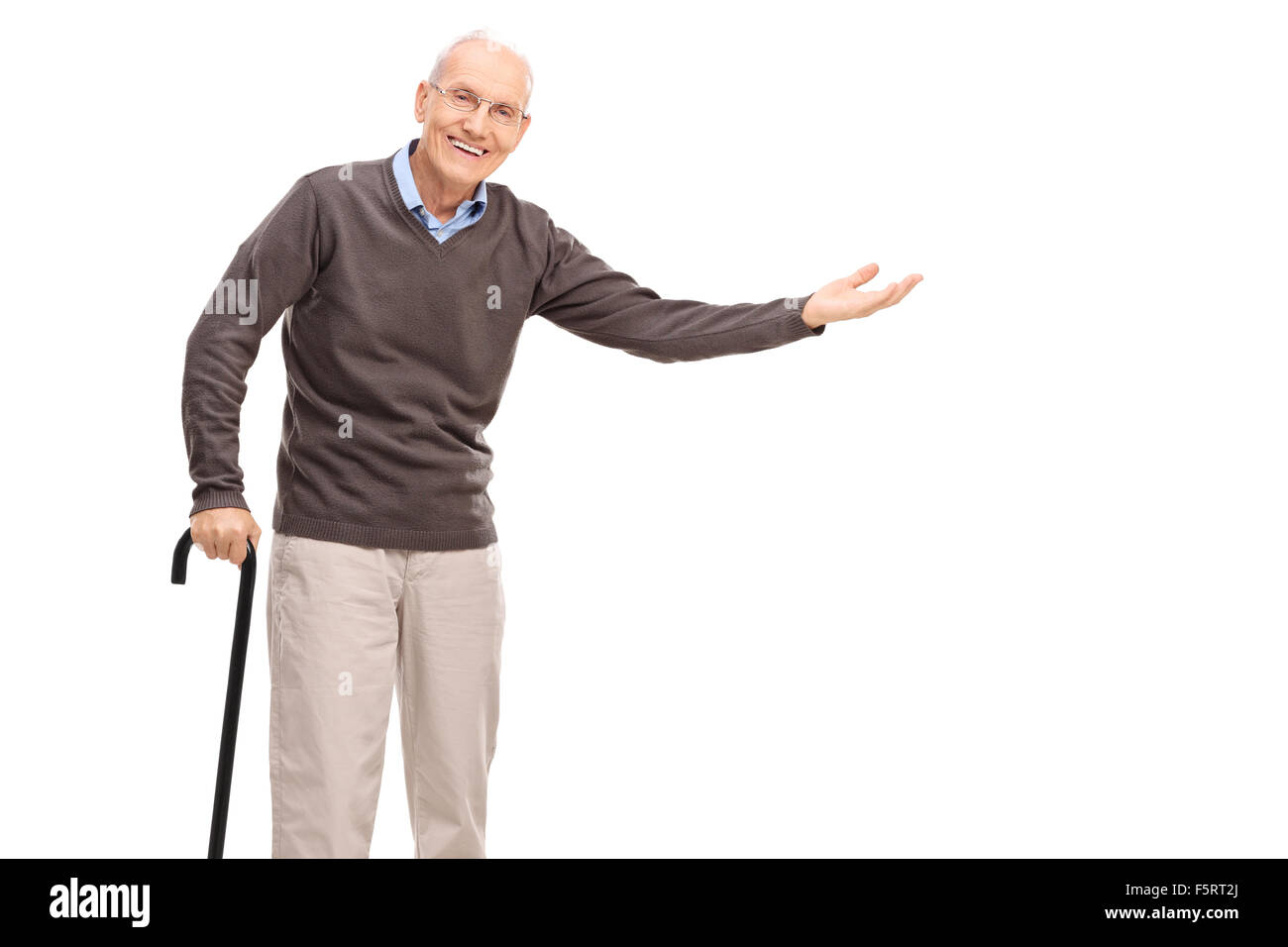 Old man with a cane smiling and gesturing with his hand isolated on white background Stock Photo