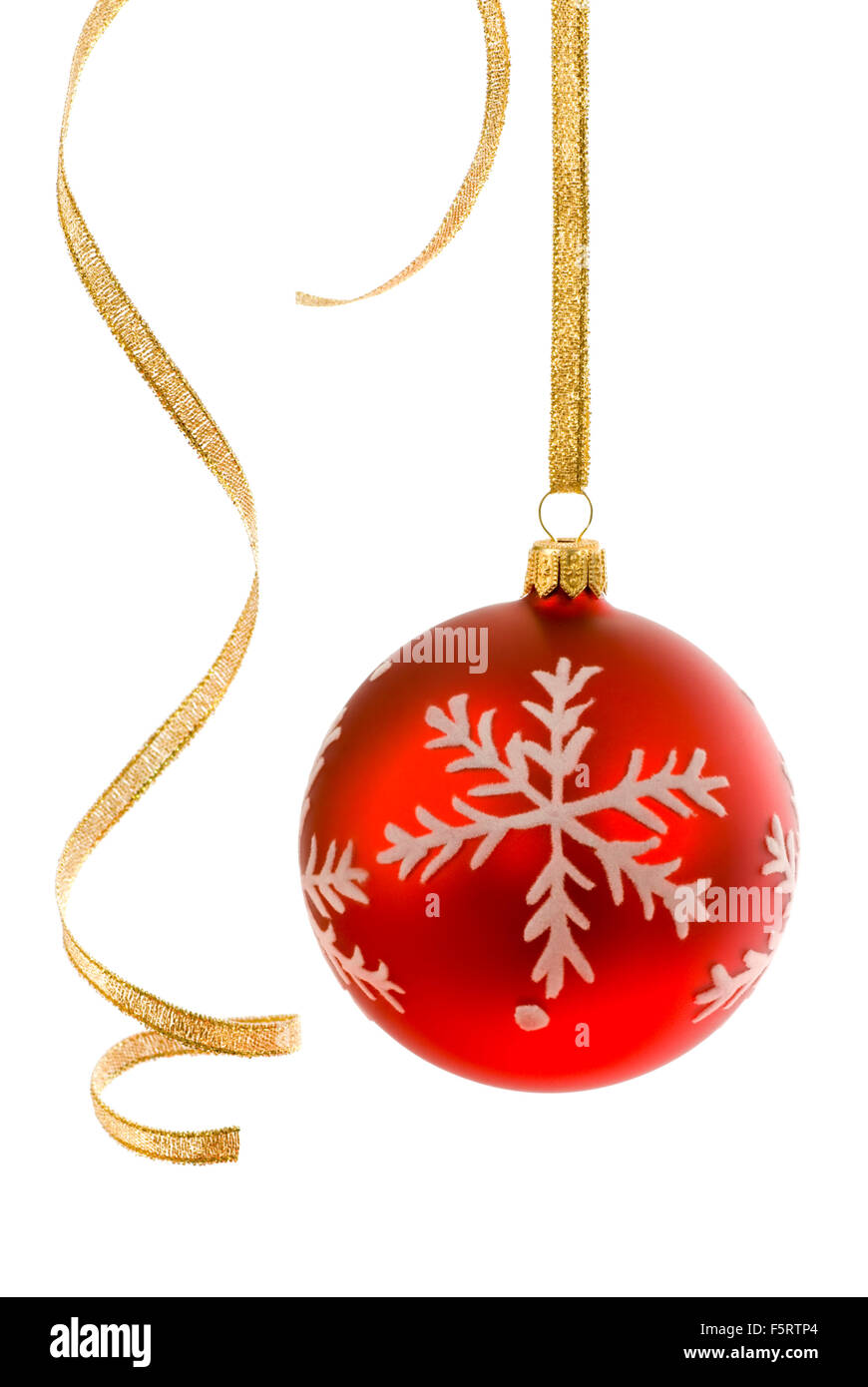 Red bauble on white, accompanied by some curly golden ribbon Stock Photo