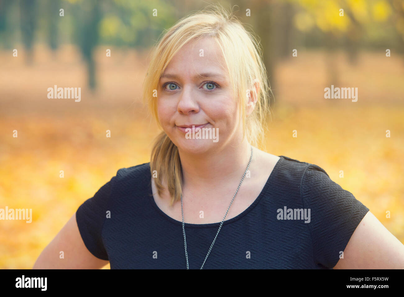 portrait of blond woman in park in the fall Stock Photo - Alamy