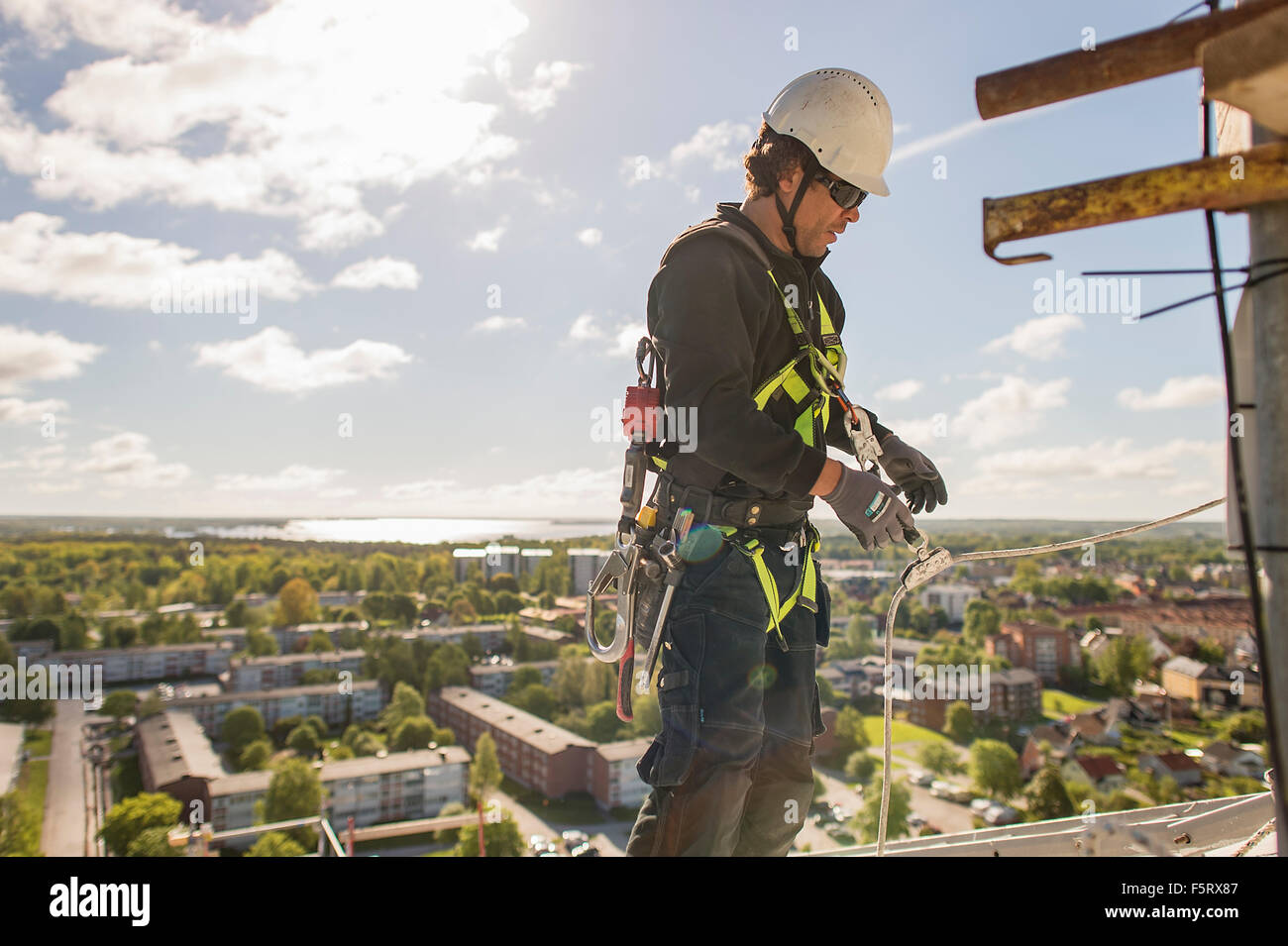 Sweden, Narke, Orebro, Construction worker high up above city Stock Photo