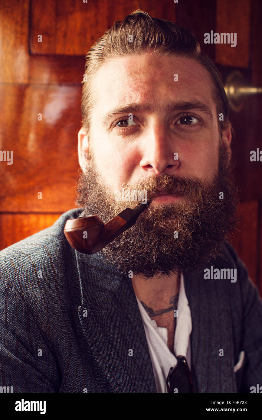 Sweden, Bearded man smoking pipe Stock Photo