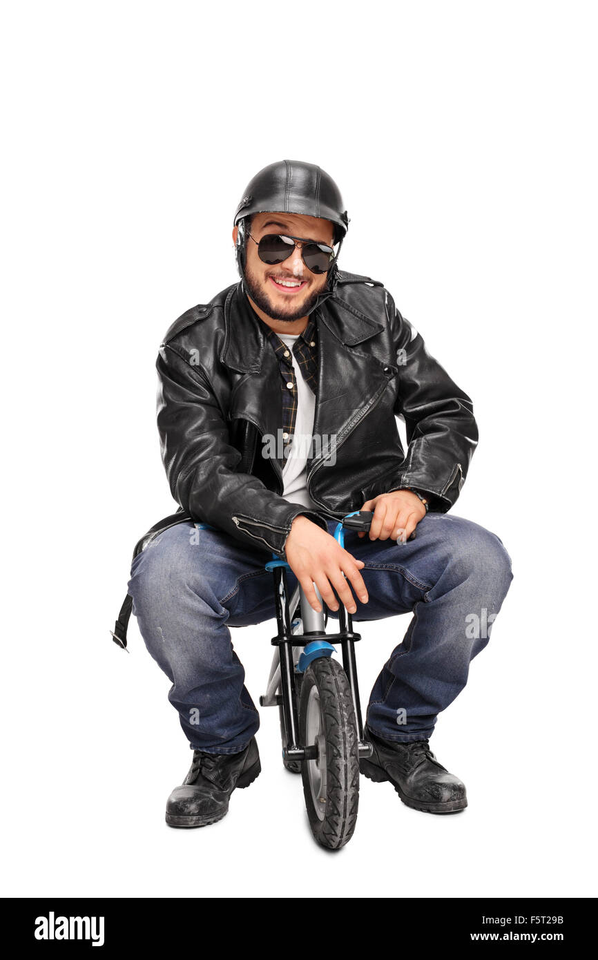 Vertical shot of a male biker in black leather jacket sitting on a small bike and looking at the camera Stock Photo