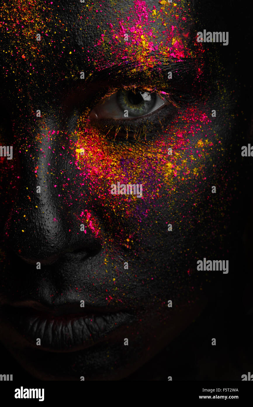 This is a portrait of the girl with creative art black makeup. There is only half of face on the picture. Bright colors. Stock Photo