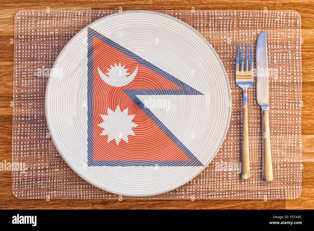 Dinner plate with the flag of Nepal on it for your international food and drink concepts. Stock Photo
