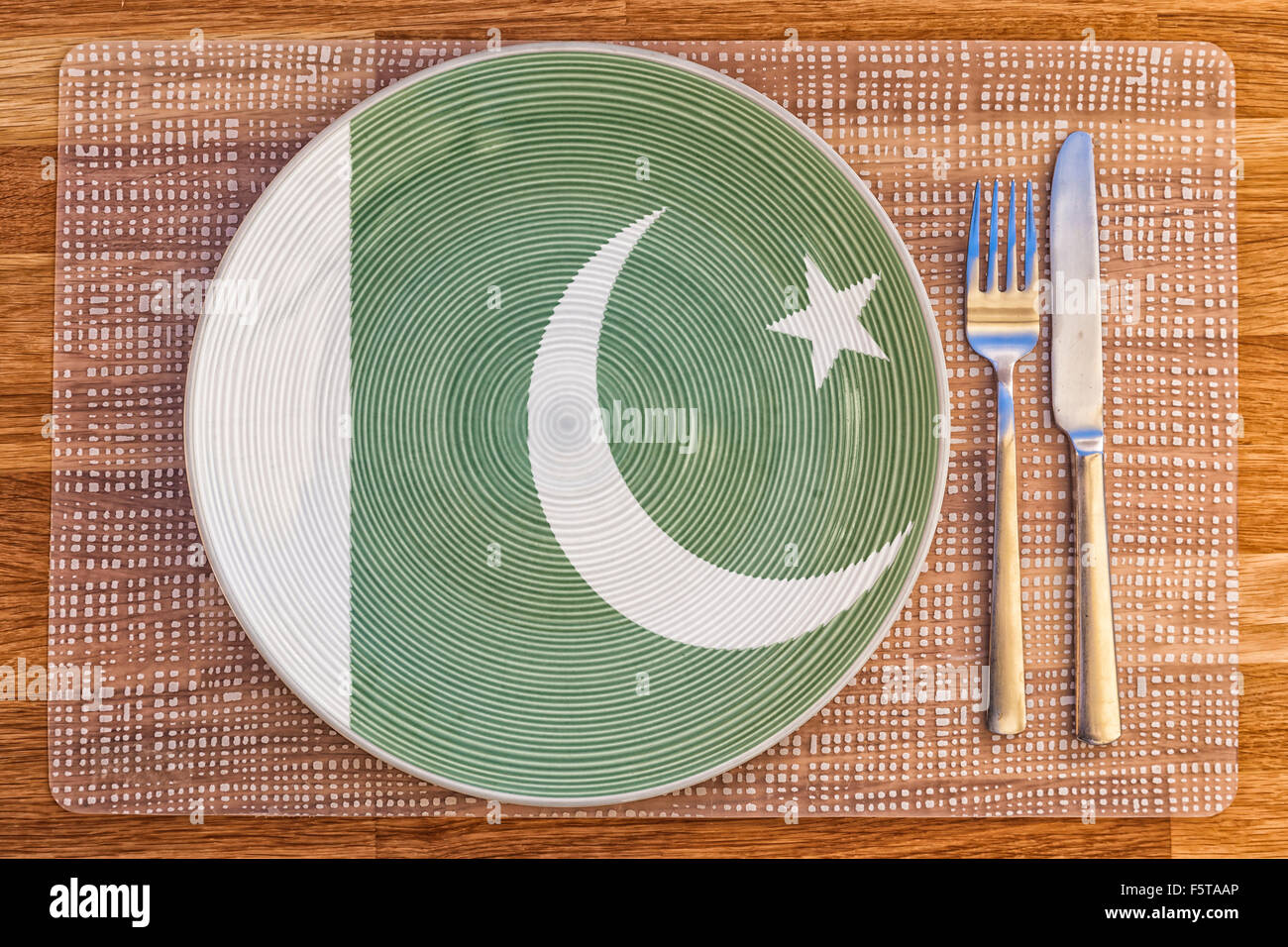 Dinner plate with the flag of Pakistan on it for your international food and drink concepts. Stock Photo