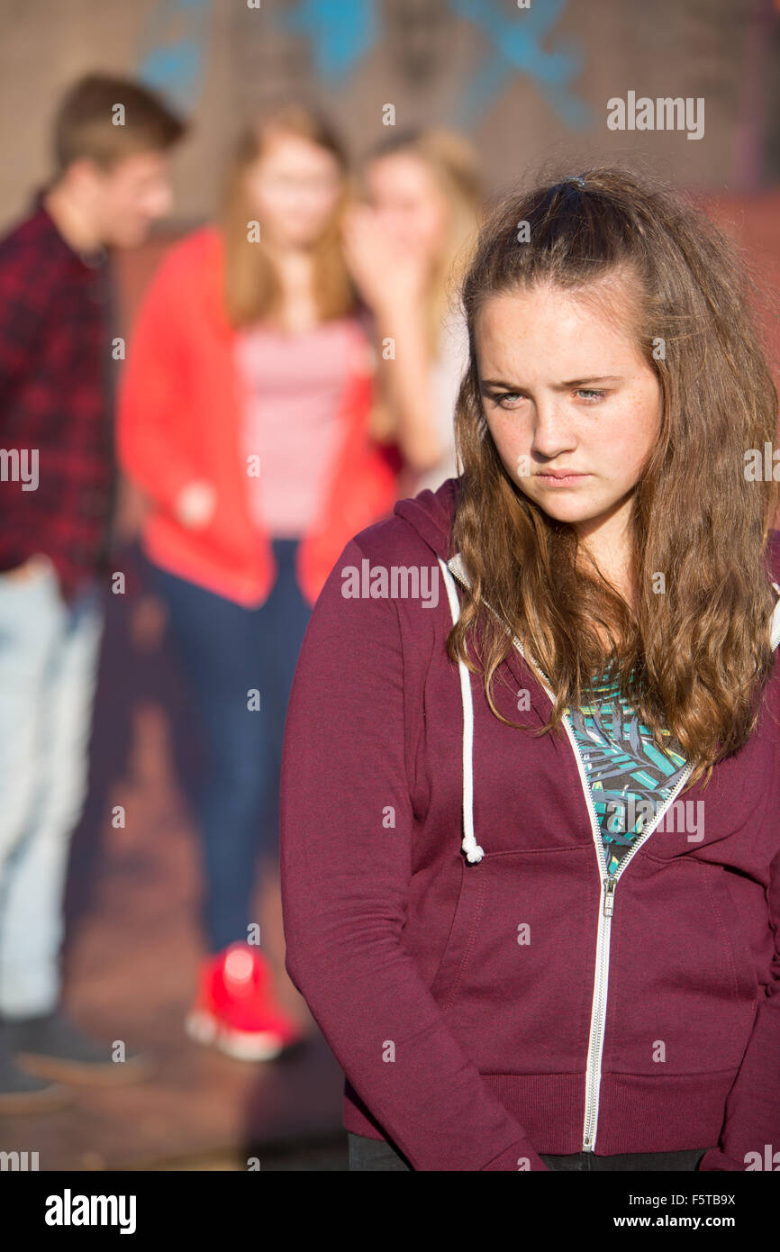 Unhappy Teenage Girl Being Gossiped About By Peers Stock Photo