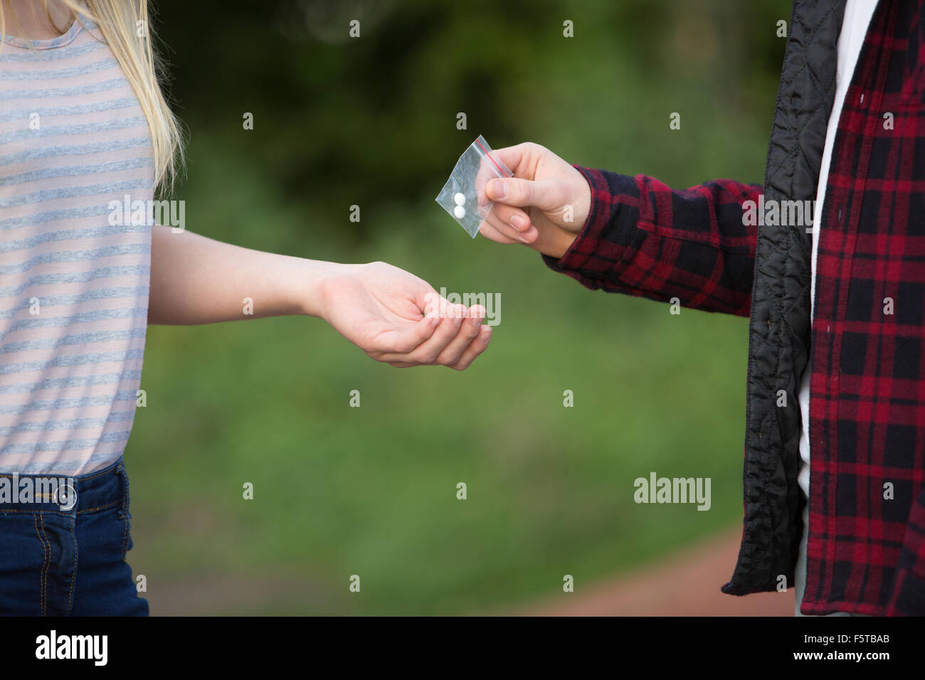 Teenage Girl Buying Drugs In Playground From Dealer Stock Photo