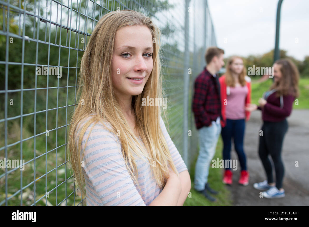 Portrait Of Teenage Girl Hanging Out With Friends In Playground Stock Photo
