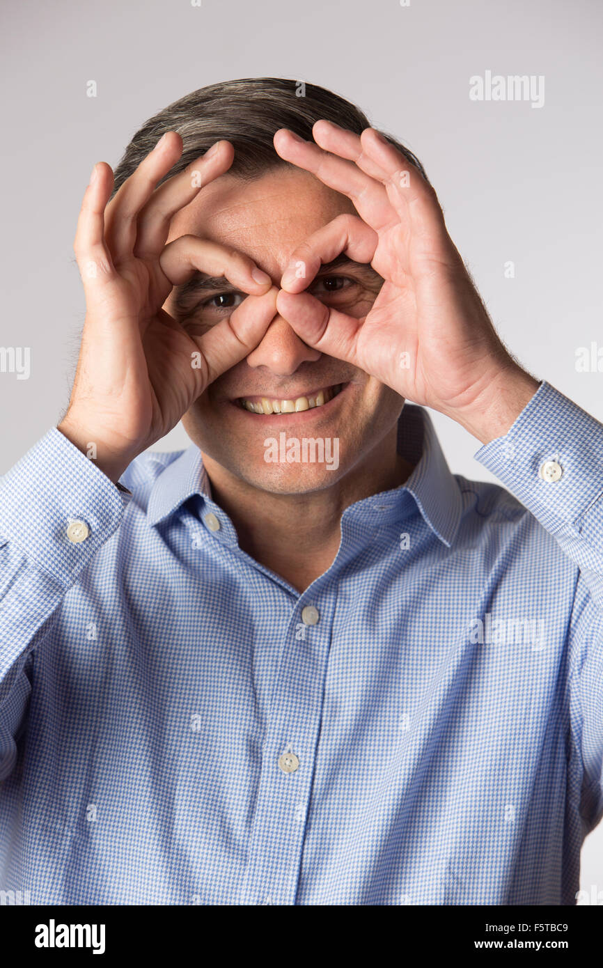 Studio Shot Of Man Making Spectacle Shape With His Hands Stock Photo