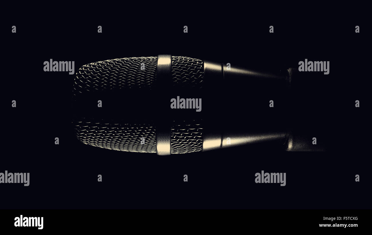Black modern microphone on stand, black dark background. Accentuated shapes with light. Stock Photo