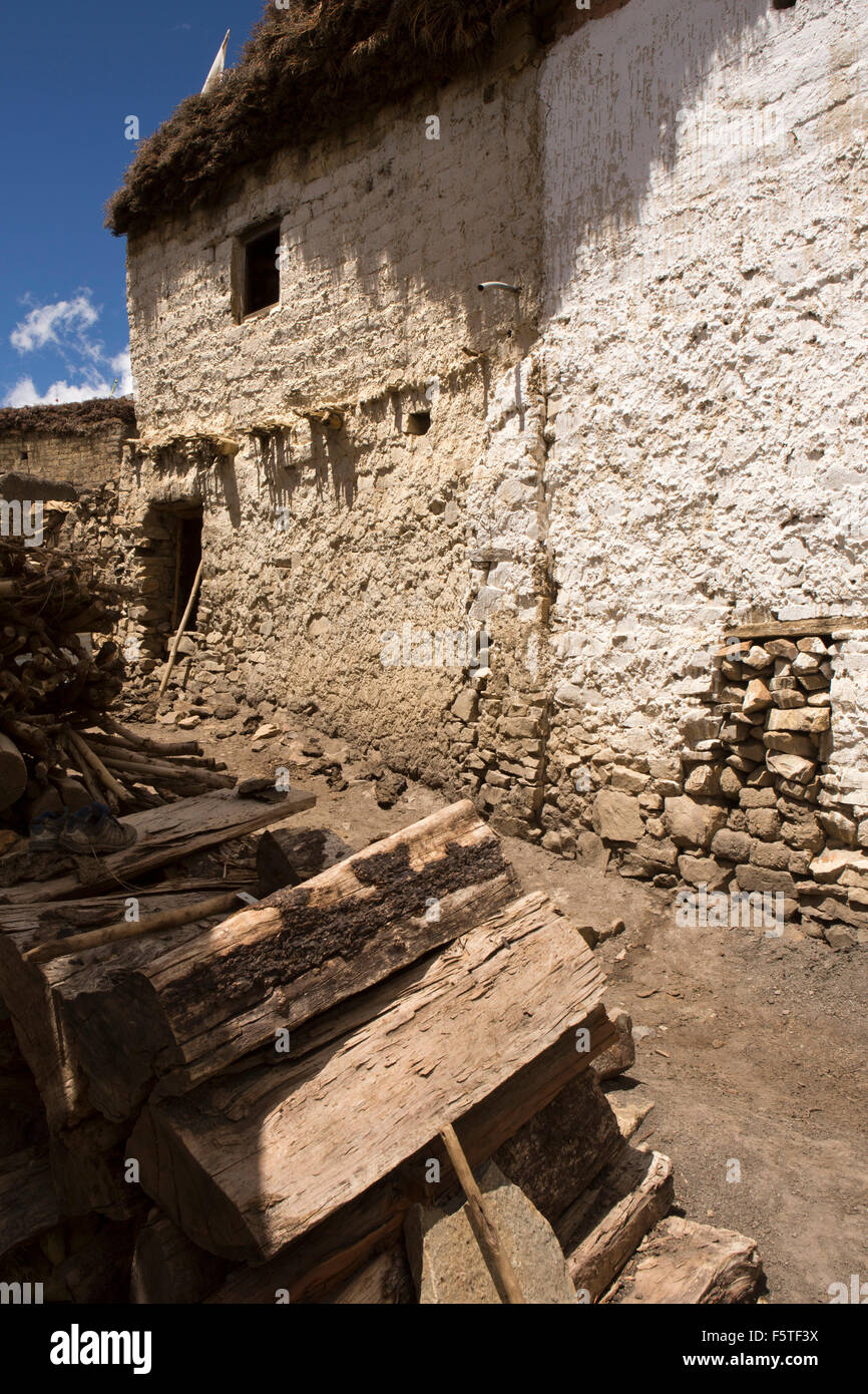 India, Himachal Pradesh, Spiti, Hikkim, wood pile outside traditionally constructed house with stone and mud rendered walls Stock Photo