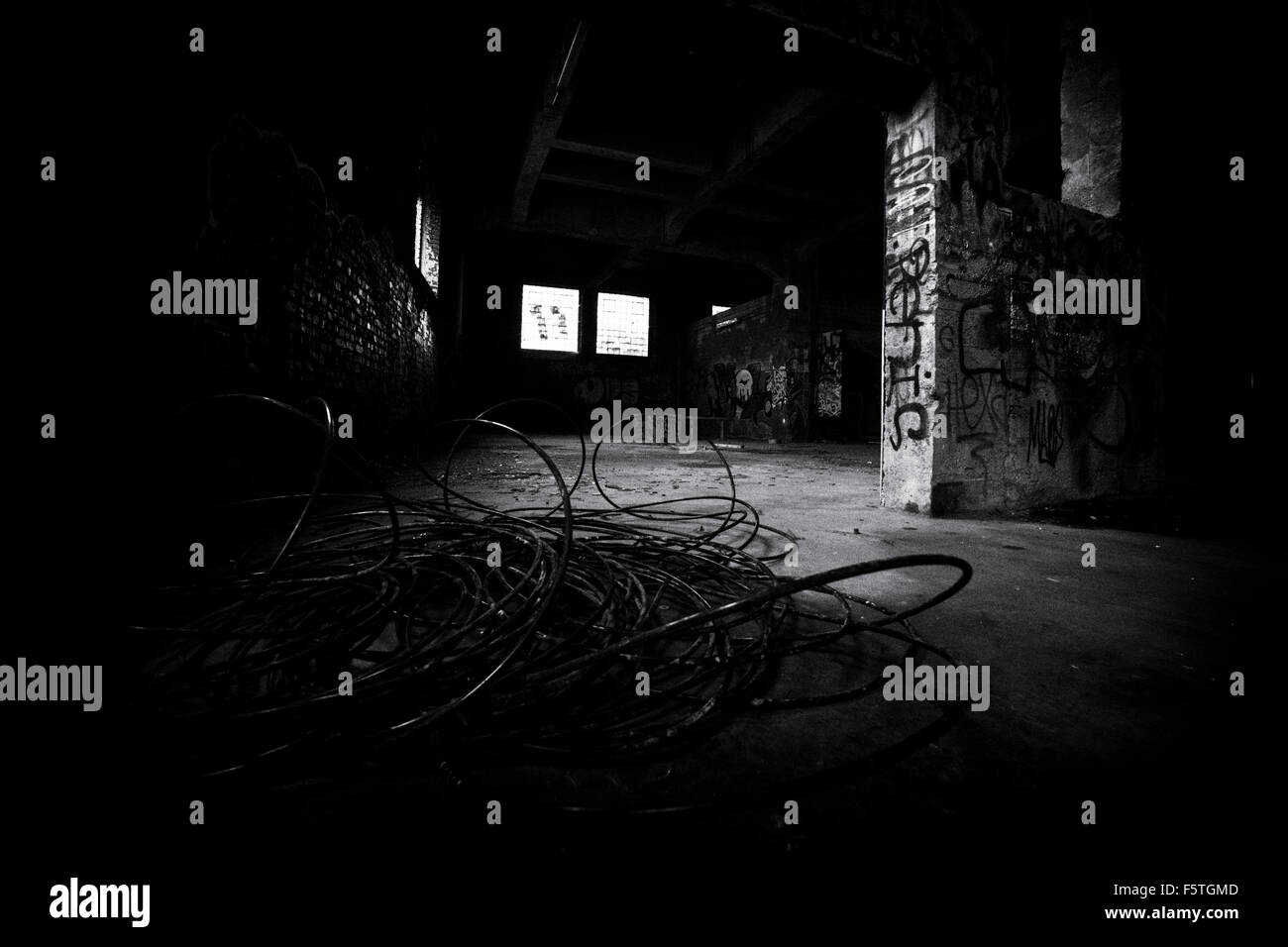 Bankrupt closed factory in Germany, empty interior with graffiti in black and white Stock Photo