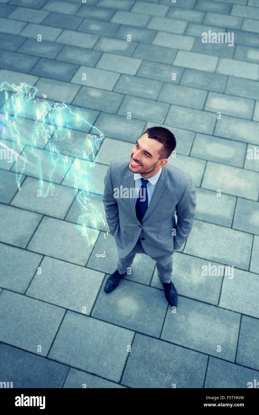 businessman with world map hologram outdoors Stock Photo