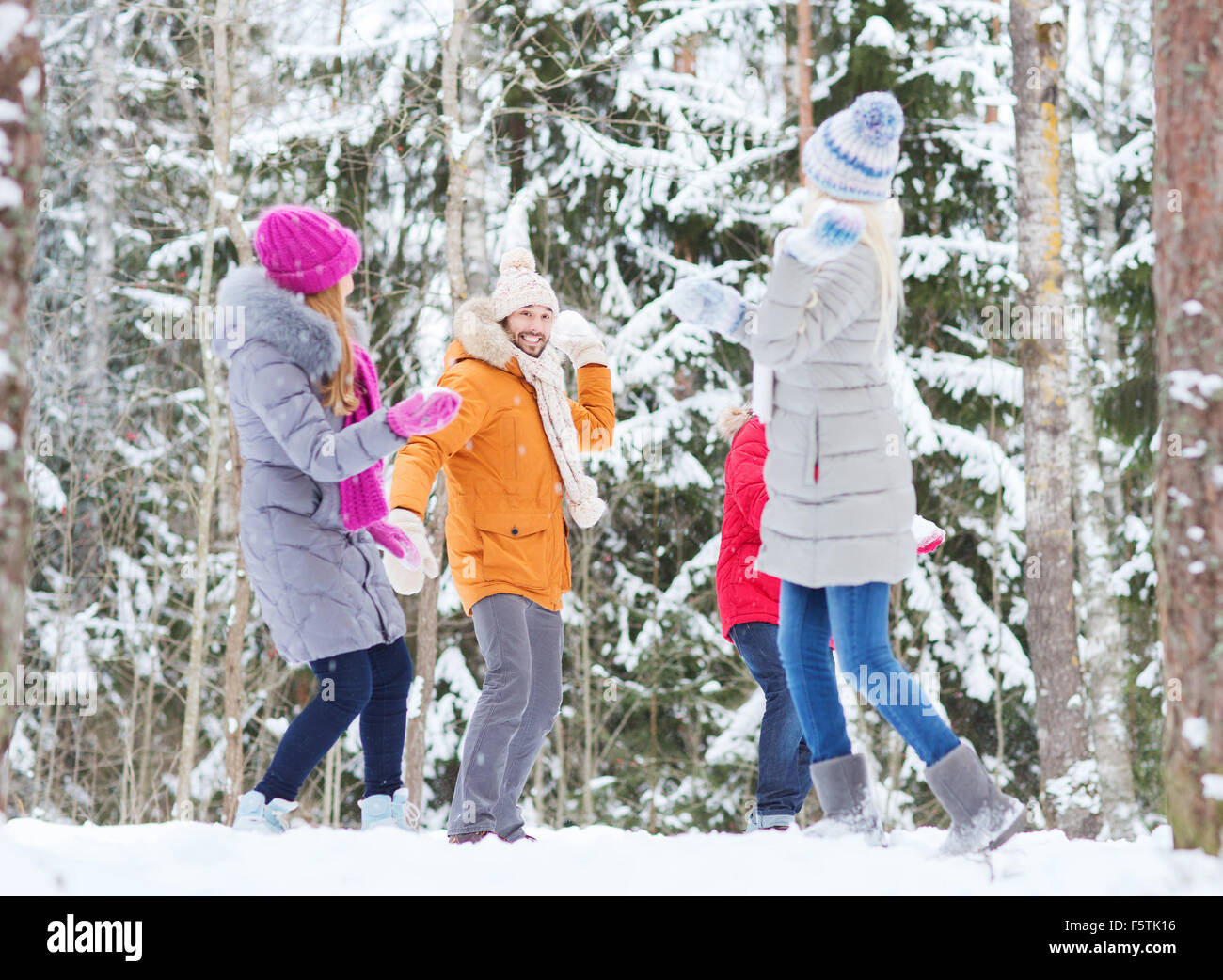 group of happy friends playing snowballs in forest Stock Photo - Alamy