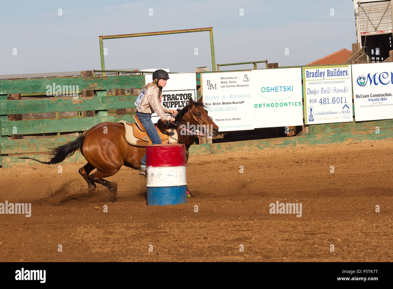 Young women compete in barrel racing at the Lincoln, California Rodeo Grounds. Stock Photo