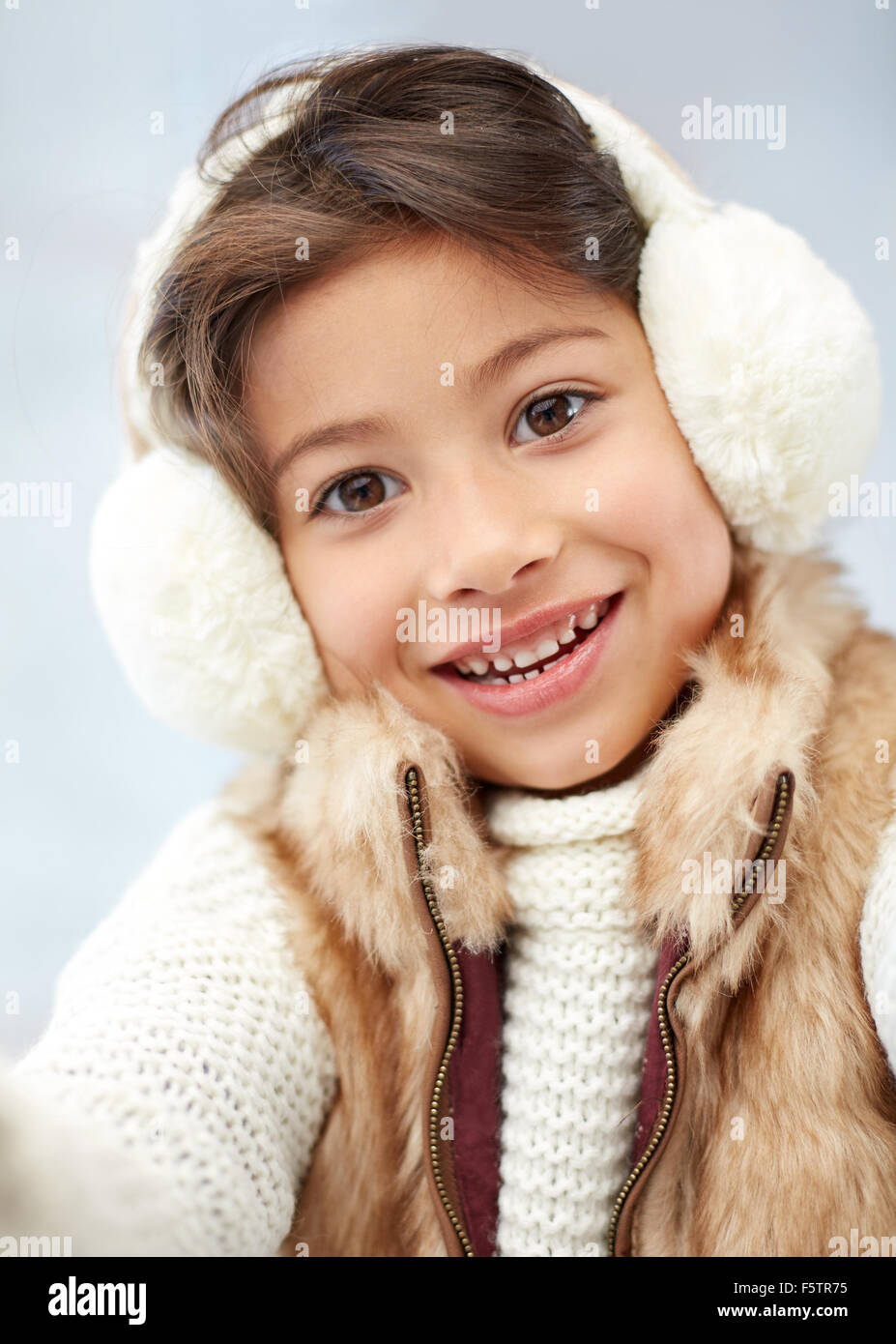 Happy little girl wearing earmuffs hires stock photography and images