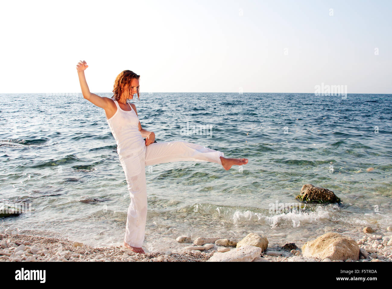 Woman in white walking barefoot on the beach Stock Photo - Alamy