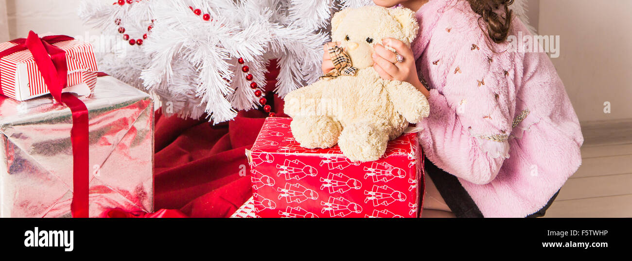 Girl Hugging Teddy Bear near christmas tree Stock Photo - Alamy