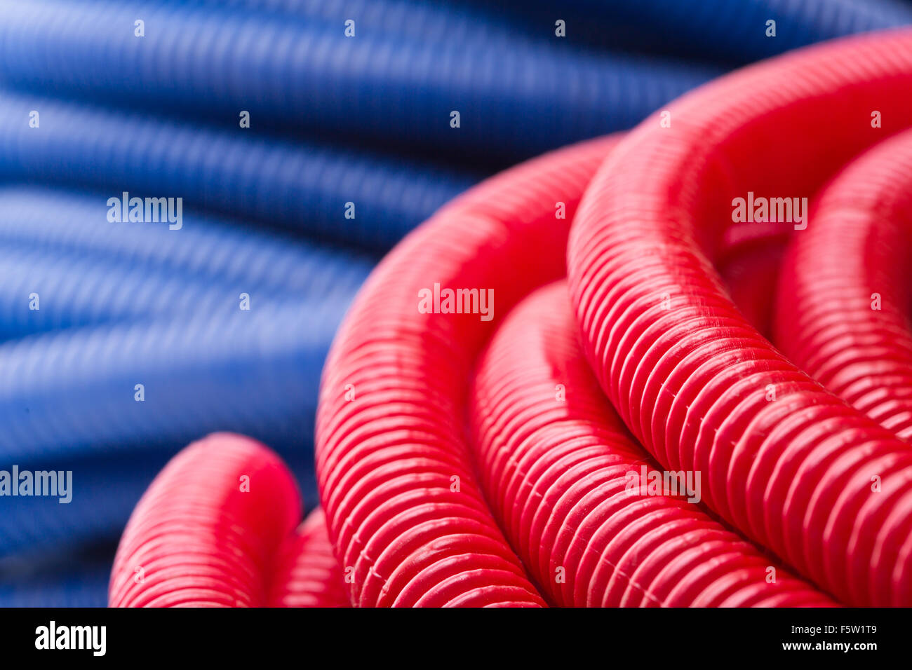 Rolls of red and blue pipes Stock Photo Alamy
