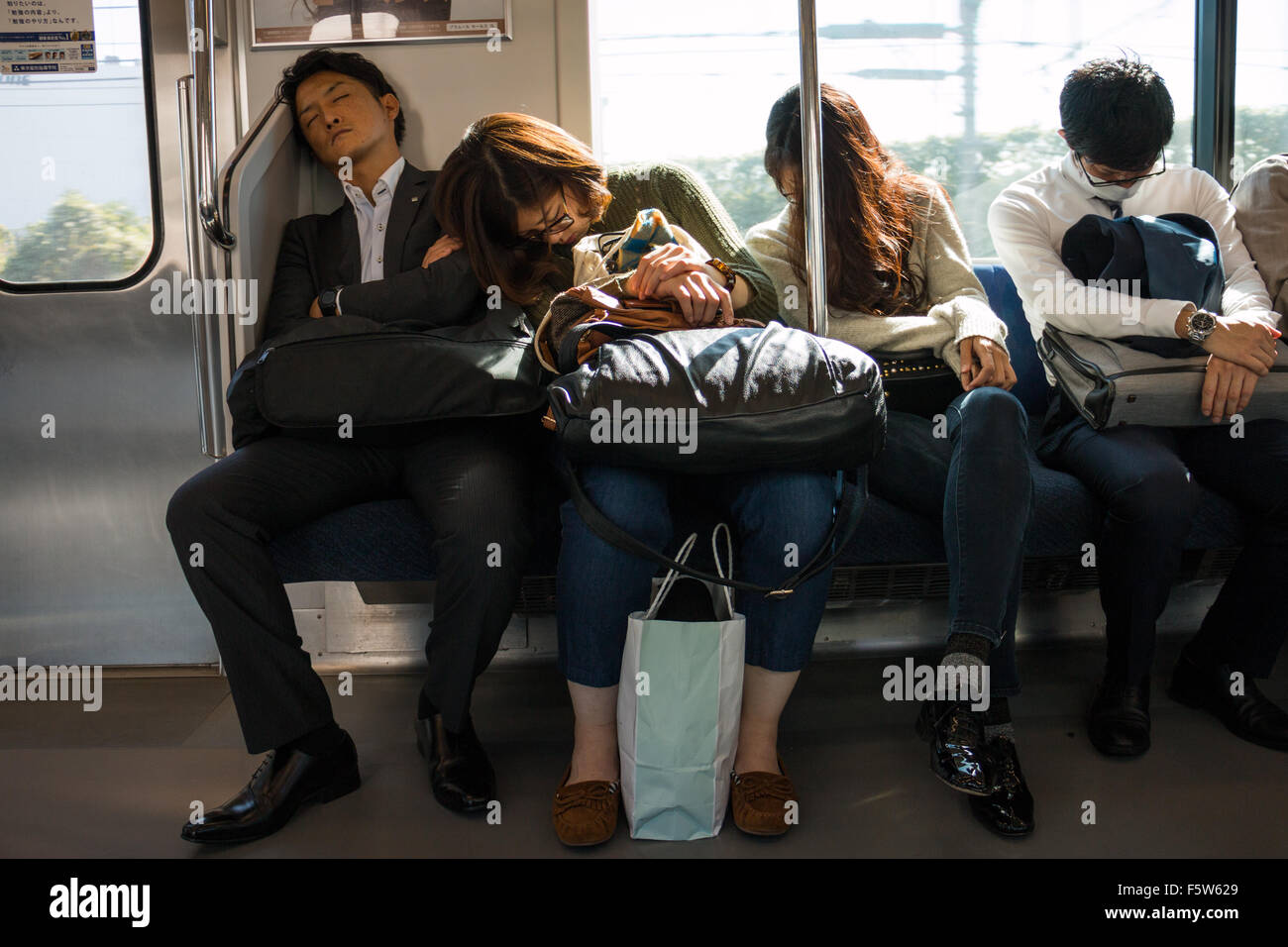 Japanese sleeping on their everyday commute on the JR Tokyo line Stock Photo