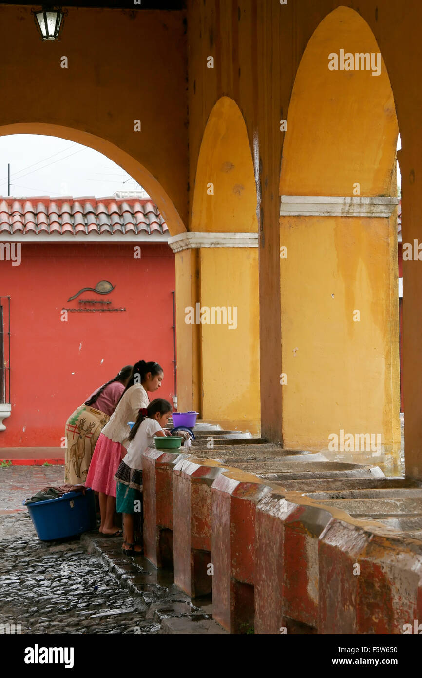 Guatemalan women wash laundry in a traditional street washing facility in Antigua, Guatemala Stock Photo