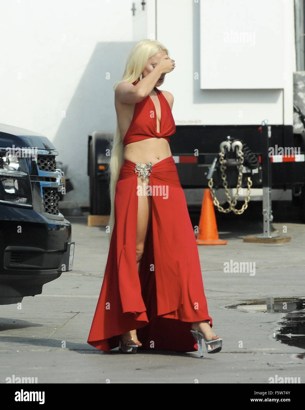 Lady Gaga leaves little to the imagination as she steps out of her trailer  in a red dress with a long slit that showed off her toned legs for a scene  in "
