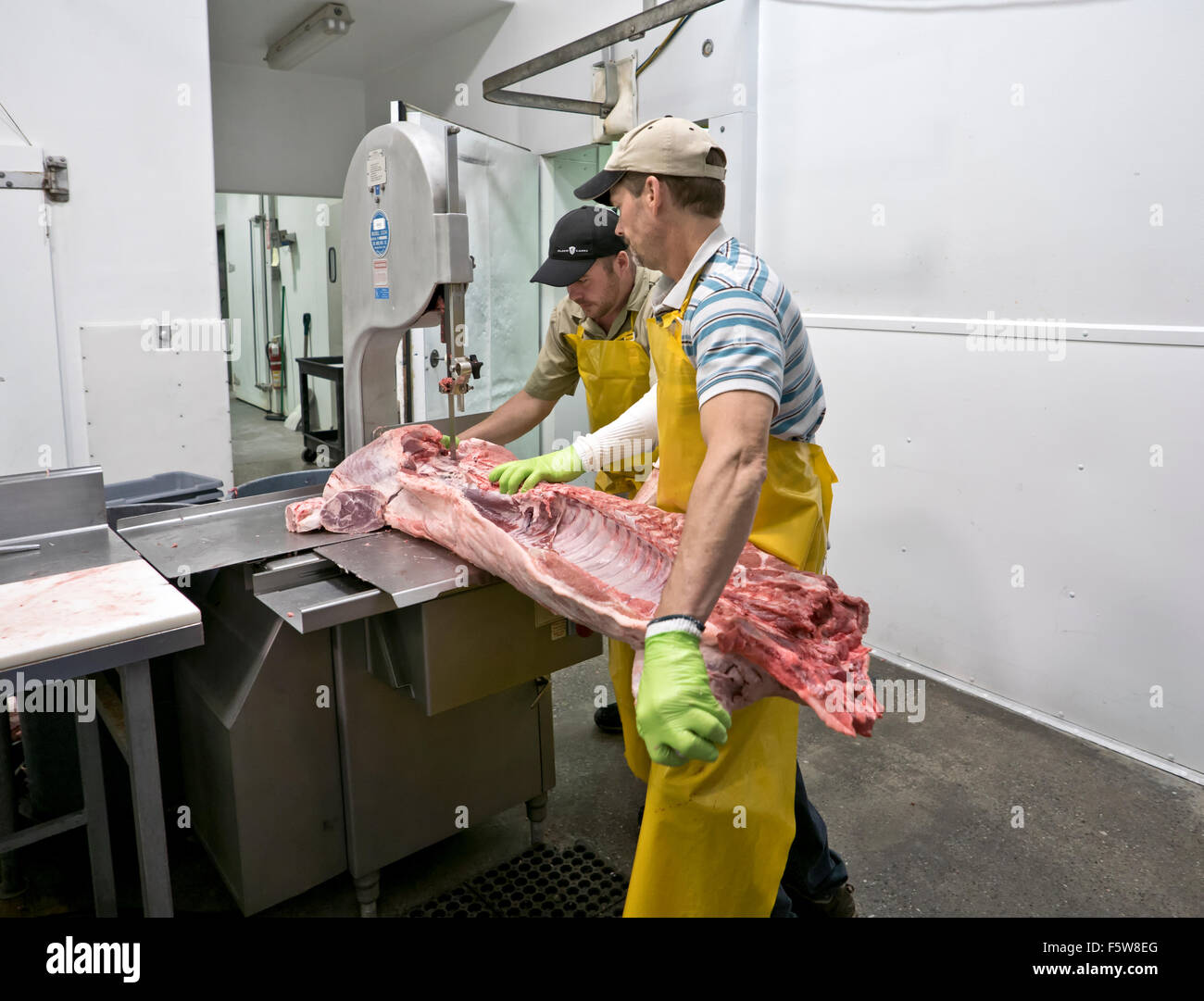 Two butchers quartering hog carcass, Delta Meat & Sausage. Stock Photo