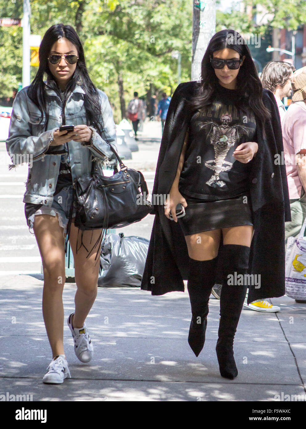 Kim Kardashian, wearing a long black coat, black knee high boots and a  Metallica t-shirt, heads out for dinner with a friend in Soho during New  York Fashion Week Featuring: Kim Kardashian