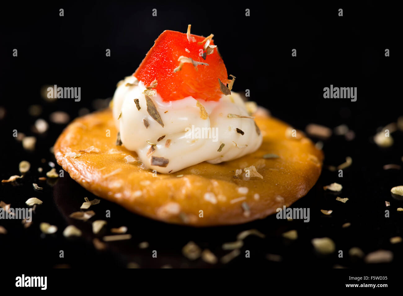 Closeup of cream cheese appetizer on cracker with red bell pepper Stock Photo