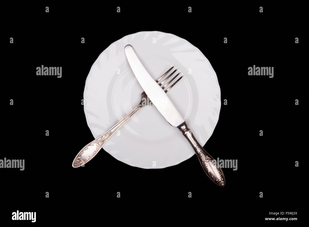 Etiquette sign. Plate, fork, knife top view isolated on black Stock Photo
