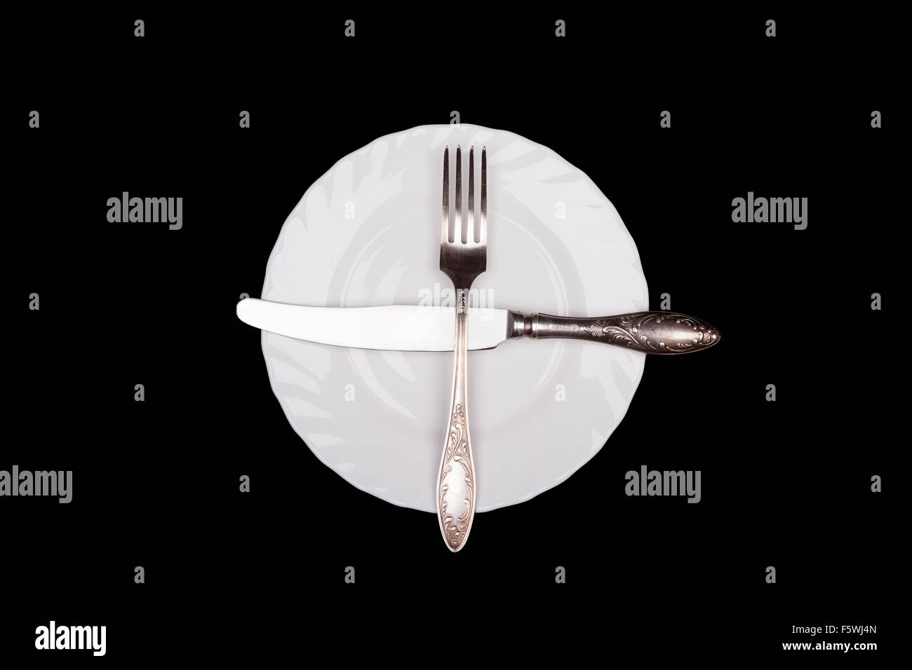 Etiquette sign. Plate, fork, knife top view isolated on black Stock