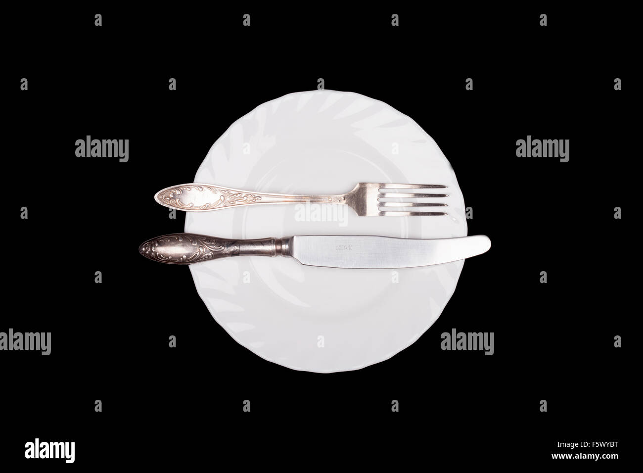 Etiquette sign. Plate, fork, knife top view isolated on black Stock Photo