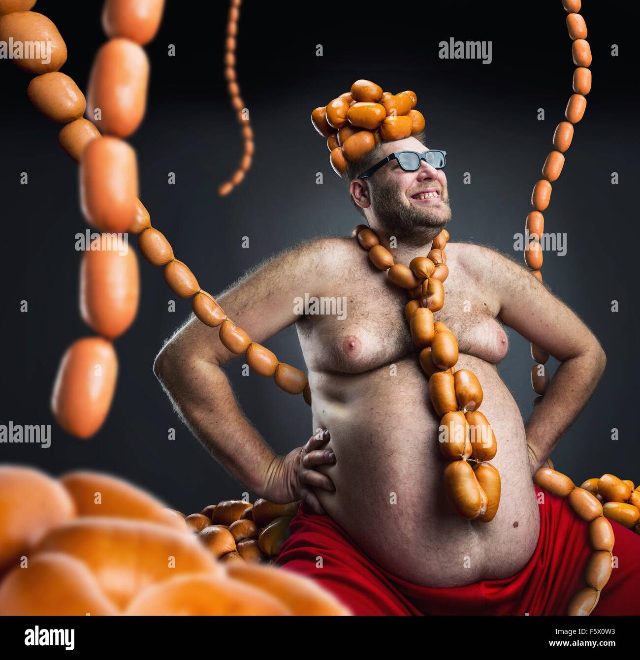 Man sitting with heap of sausages on his head and with sausages round his  neck Stock Photo - Alamy