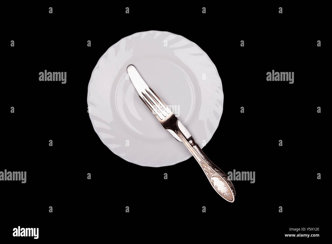Etiquette sign. Plate, fork, knife top view isolated black background Stock Photo