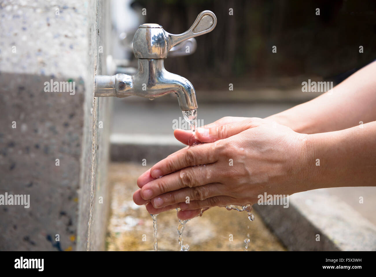 Washing of hands  under running water outdoor Stock Photo