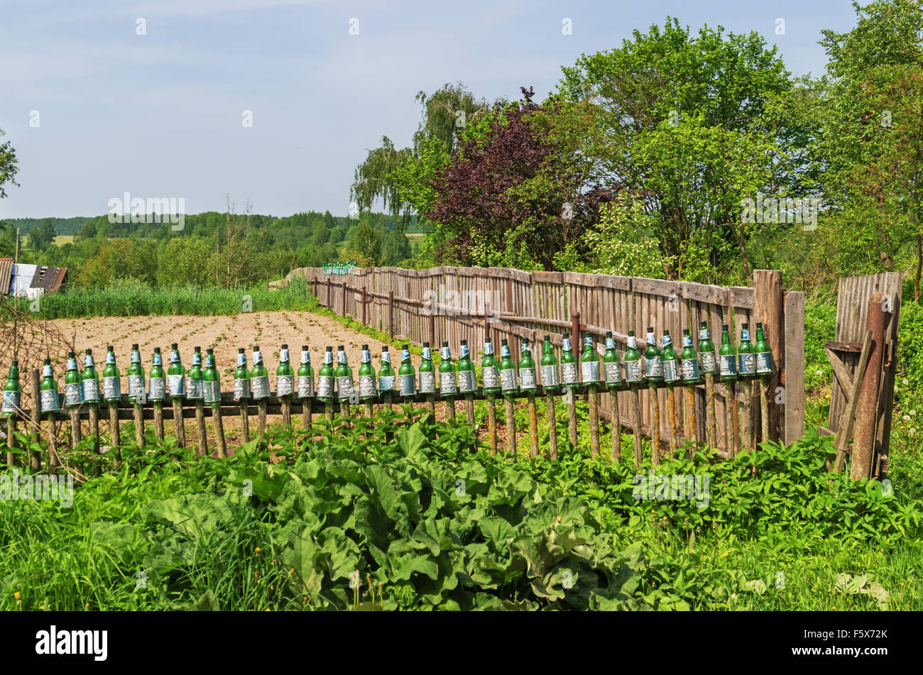 Green Plastic Bottles On A Kitchen Garden Fence Stock Photo