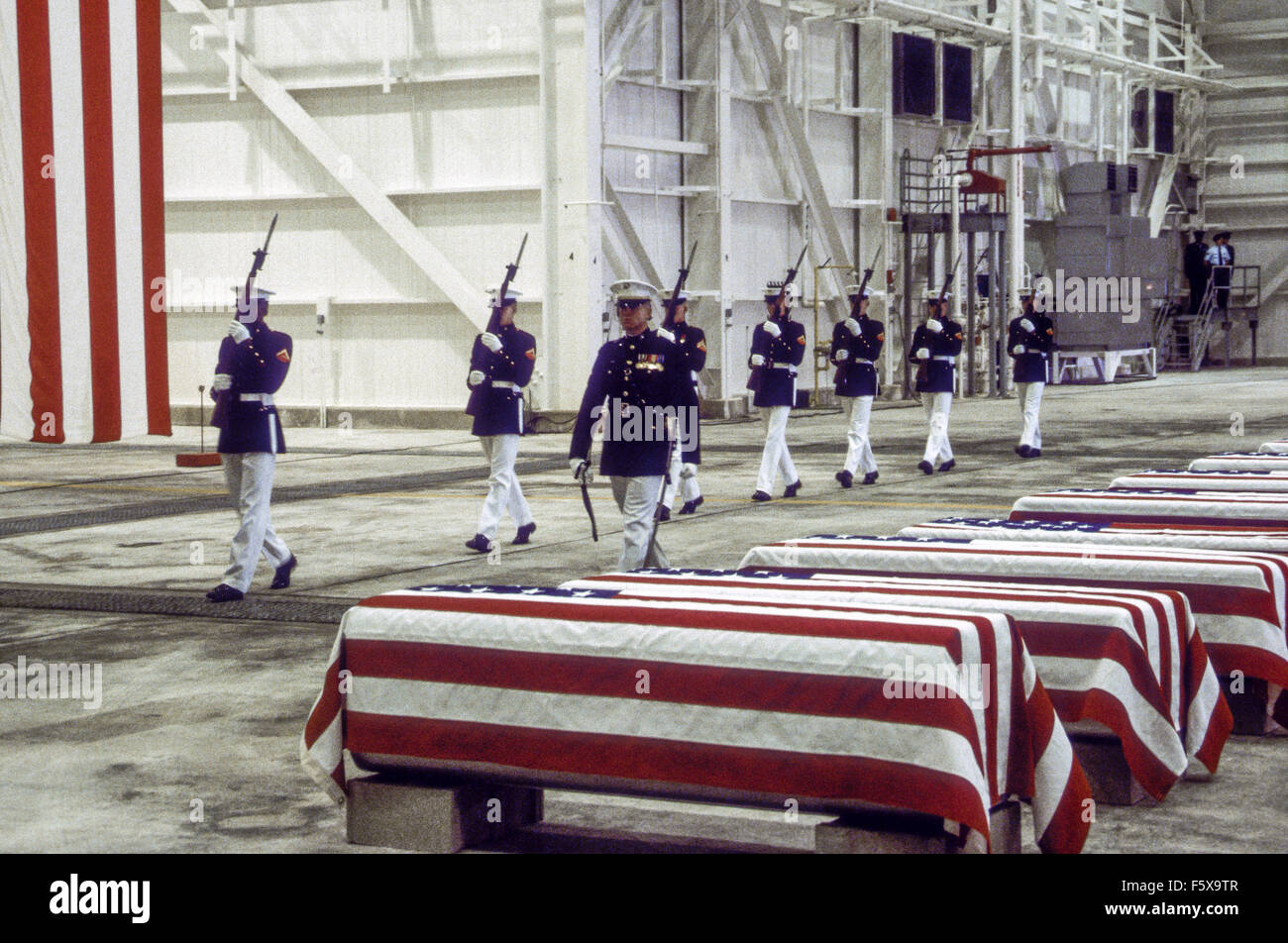 Dover Air Force Base, Delaware, USA. 29th October 1983 At precisely 7 A.M., a Marine honor guard and a color guard in ceremonial dress uniforms marched into a huge hangar at the Dover Air Force Base and stood facing 16 coffins. Behind them, suspended from the beams of the hangar, was a 38-foot American flag. The ceremony was the first on American soil honoring servicemen killed in the bombing in Beirut and the invasion of Grenada. Credit: Mark Reinstein Stock Photo