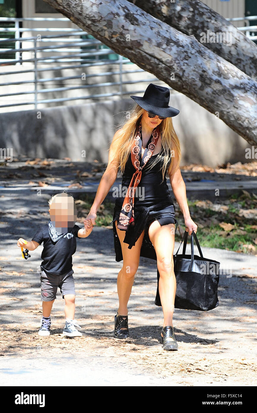 Fergie in a black skimpy outfit and black hat, takes her son Axl to the