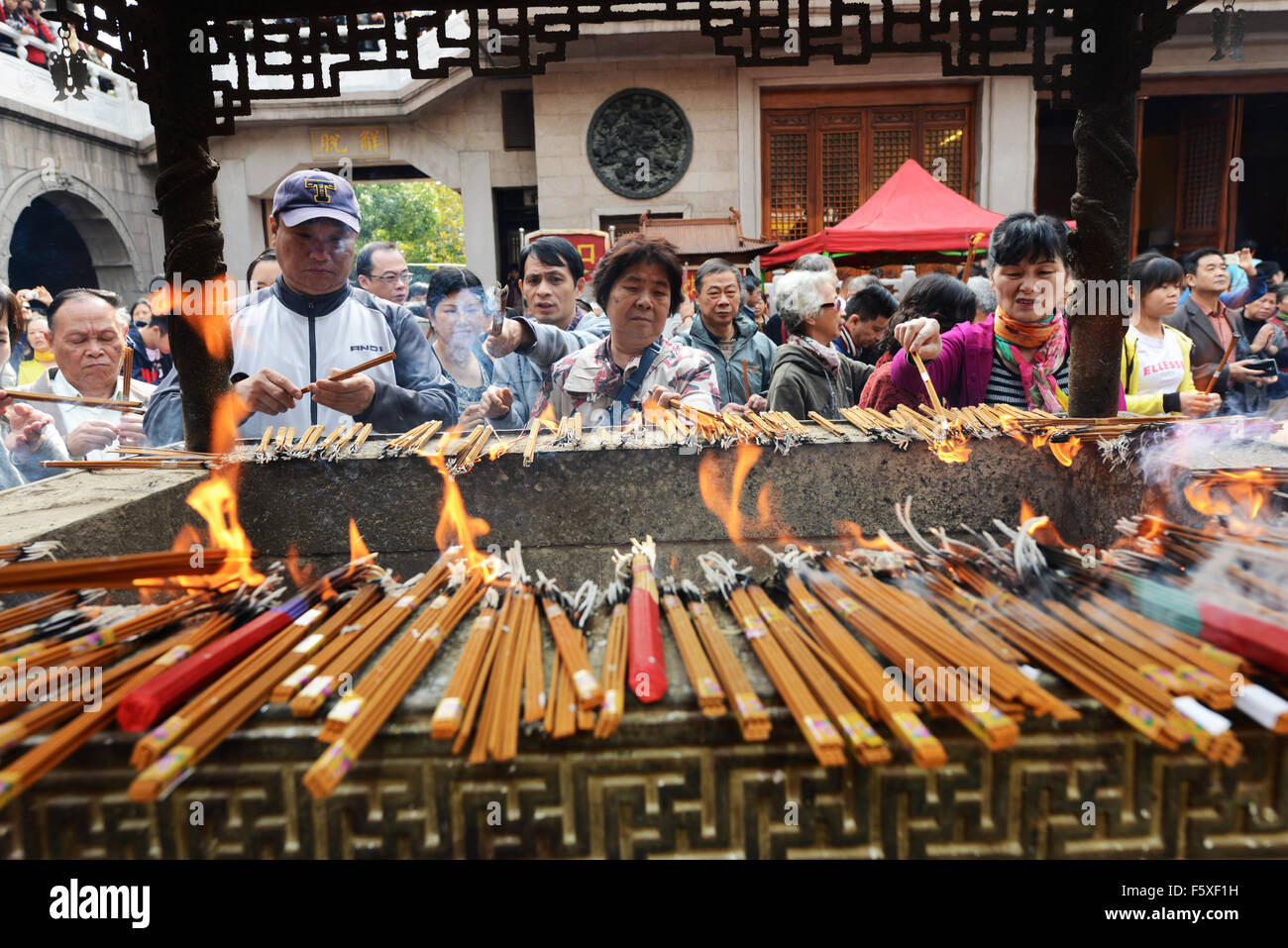 Lighting incense sticks during a Buddhist ceremony at the Jade Buddha temple in Shanghai. Stock Photo