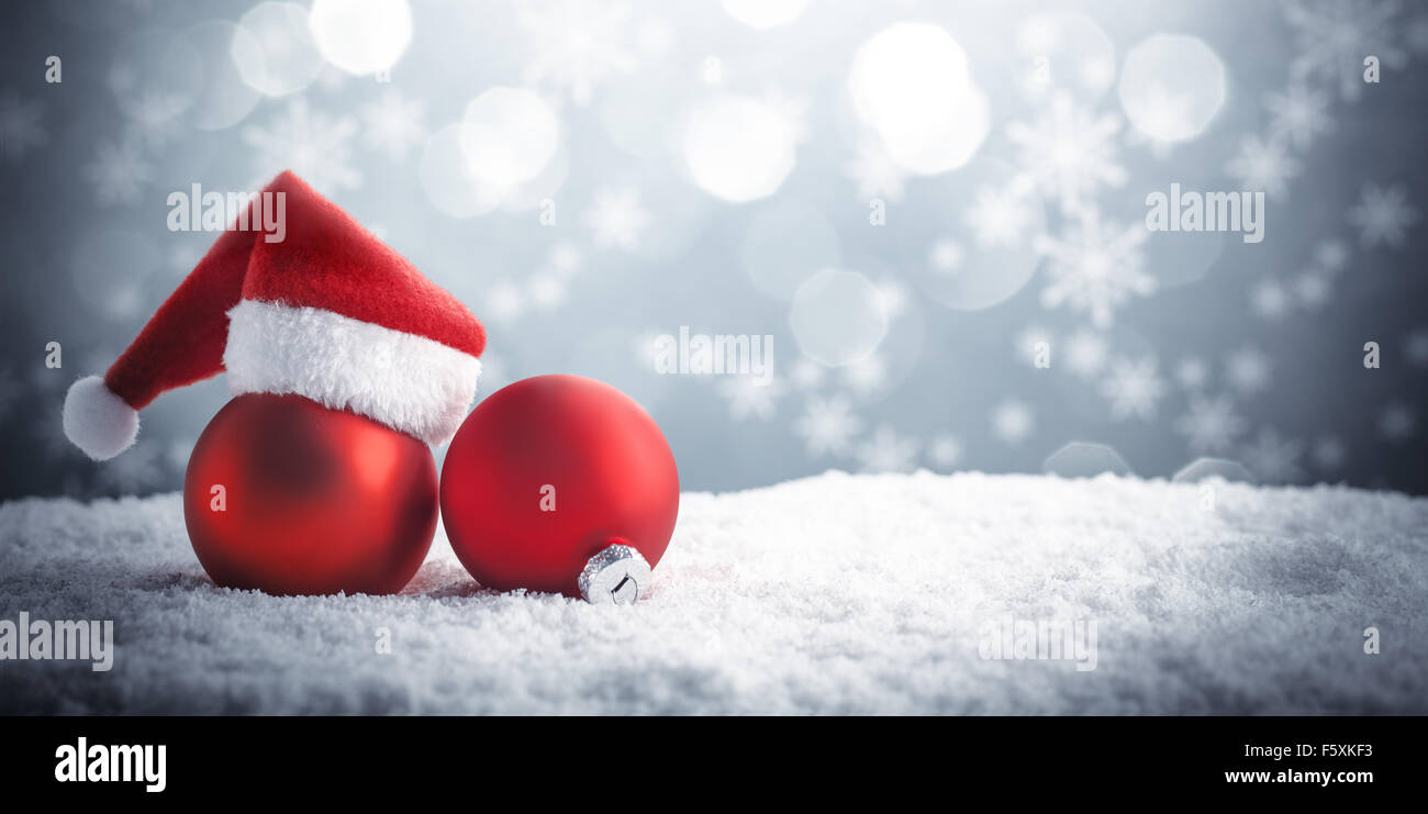 Christmas ball in the hat of Santa Claus on snow. Stock Photo