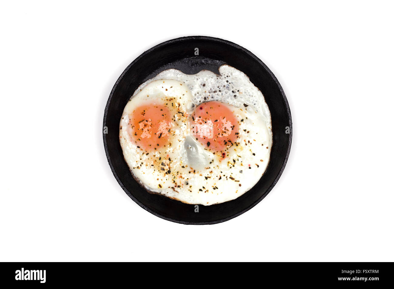 Scrambled eggs in black iron skillet, top view isolated white Stock