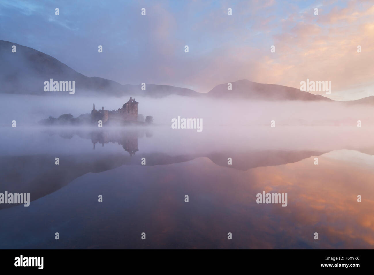 Kilchurn Castle and Loch Awe viewed through the mist at sunrise, Kilchurn Bay, Argyll and Bute, Highlands, Scotland. Stock Photo