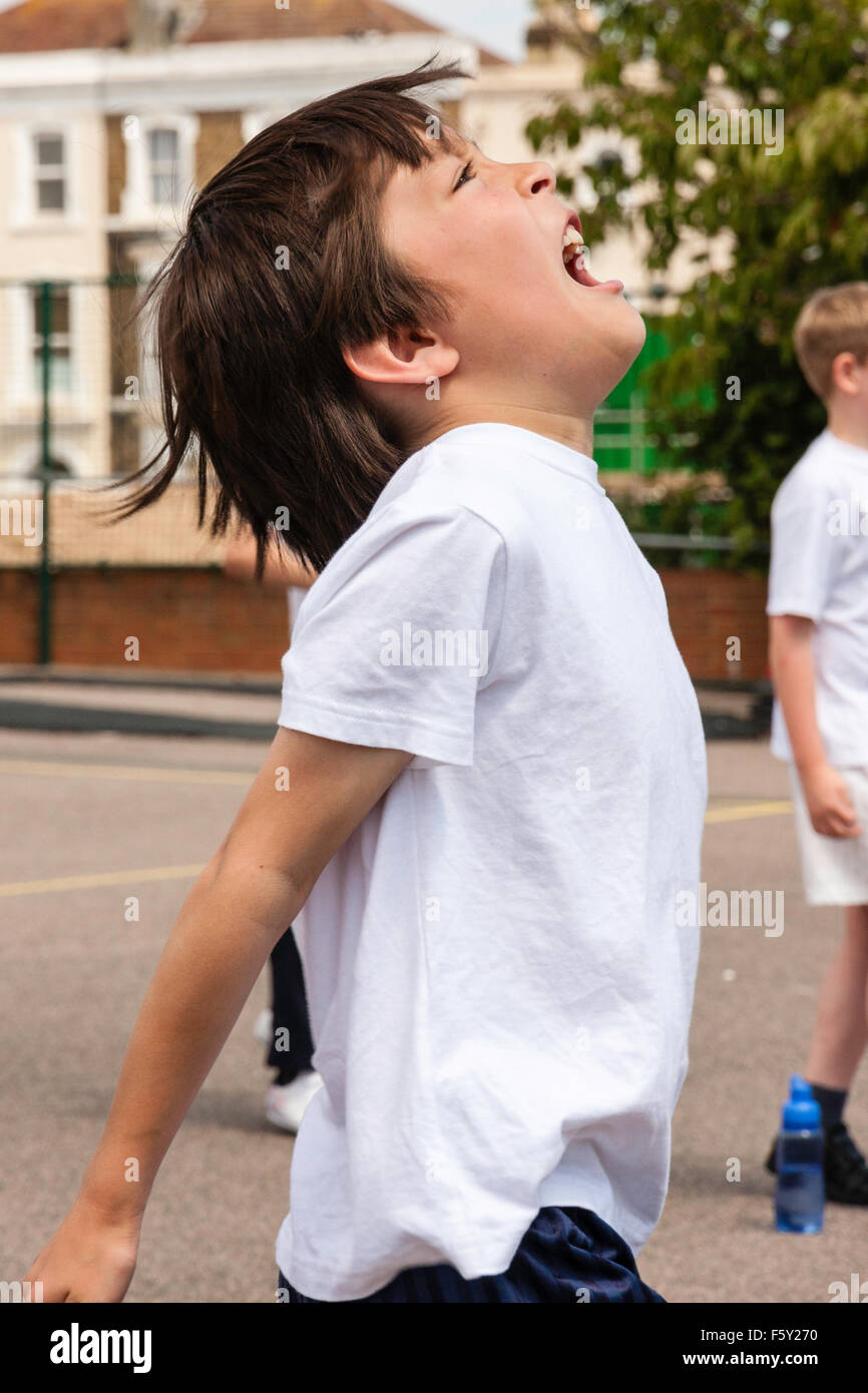 Child, Caucasian boy, 8-9 years old. Outdoors at School sports day. Jumping up and yelling after scoring netball goal, the 'YES!' moment. Stock Photo