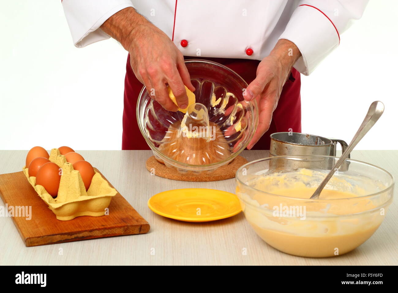 Greasing cake pan with margarine or butter. Making bundt cake with chocolate glaze. Stock Photo