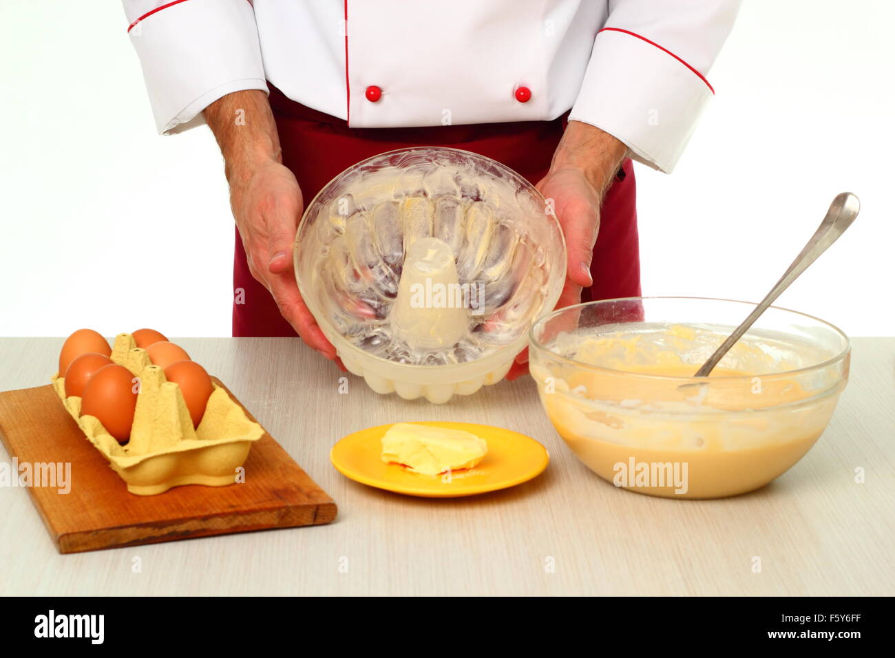 Greasing cake pan with margarine or butter. Making bundt cake with chocolate glaze. Stock Photo
